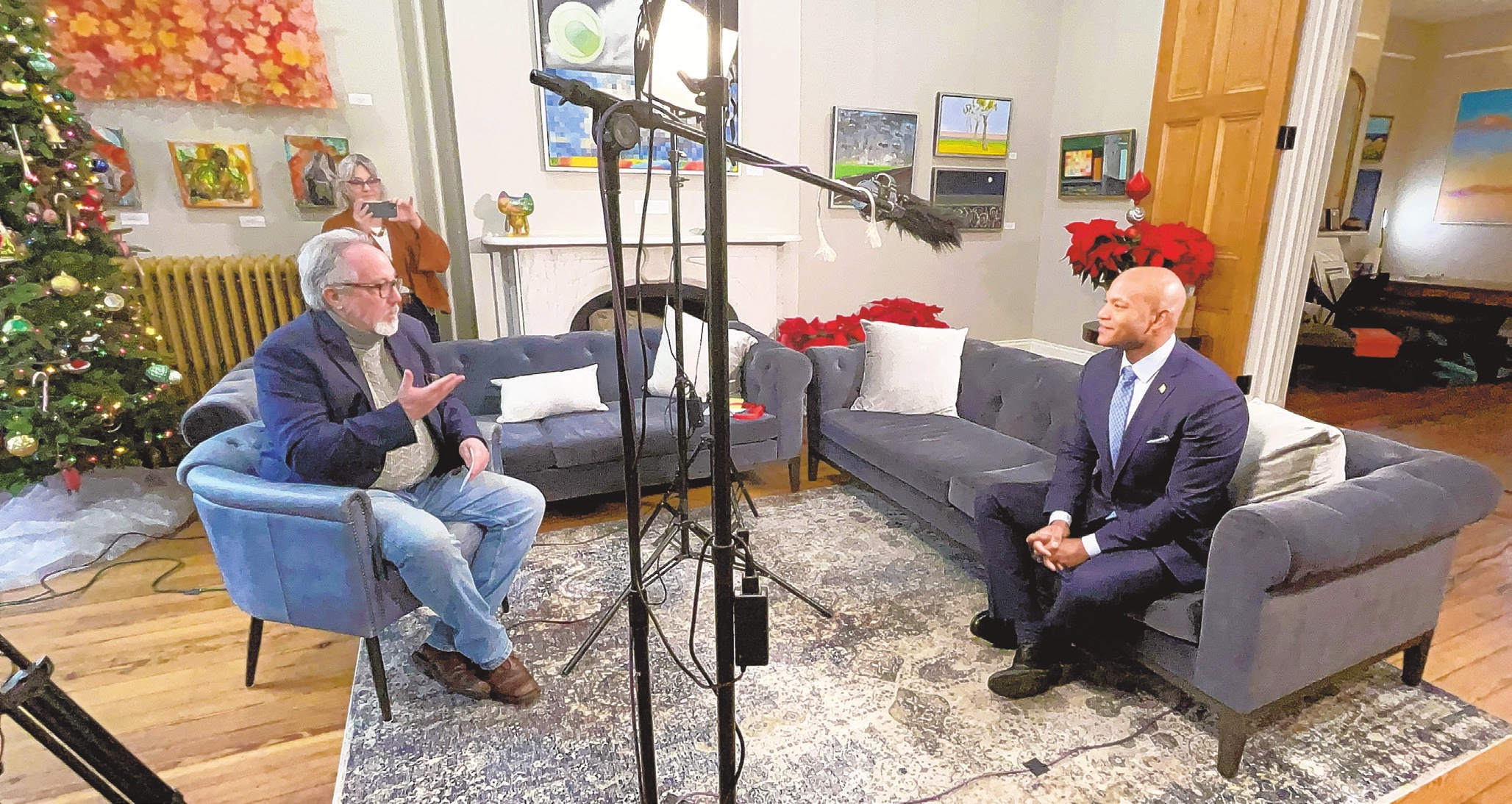 Russ Hodge interviews Maryland Governor Wes Moore, with Cynthia Scott documenting the conversation in the background